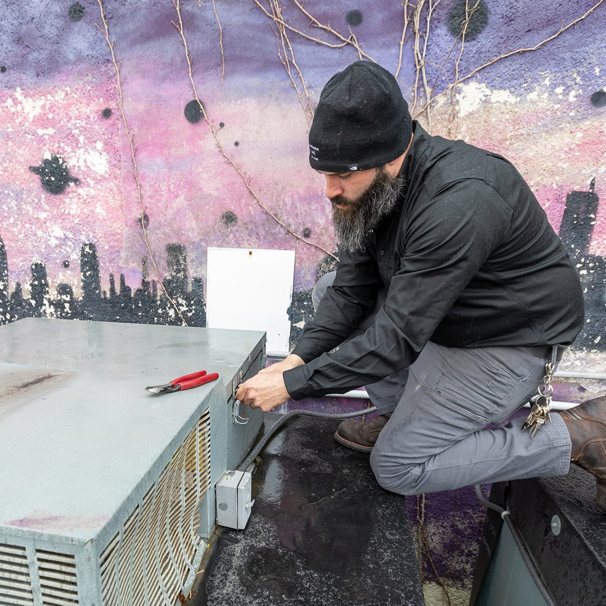 Technician repairing a commercial rooftop heating unit